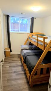a bedroom with two bunk beds and a window at Niagara Escape Crib: 3km from NiagaraFalls in Niagara Falls