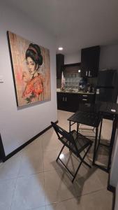 a kitchen with a painting of a woman on the wall at Green Cocoon at Bali beach in Sanur