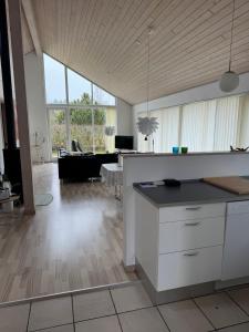 a kitchen and living room with a couch and a table at Marielyst feriehus in Bøtø By +6 photos