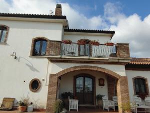 a house with a balcony with chairs on it at I Dolci Grappoli in Larino