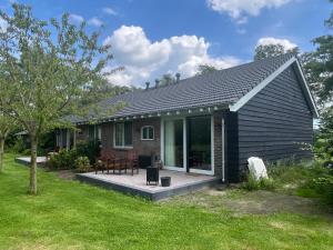 a small house with a deck and a patio at In de Hemmele bij Maria in Lievelde