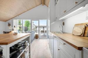 a kitchen with white cabinets and a large window at 3046-Stege-Paelen-46 in Stege +13 photos