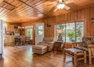 a living room with wooden walls and a ceiling fan at Pinewood - Bouchard Shores Resort in Minocqua