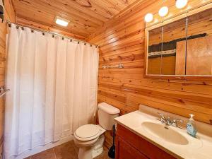 a wooden bathroom with a toilet and a sink at Pinewood - Bouchard Shores Resort in Minocqua +12 photos