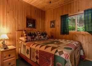 a bedroom with a bed in a wooden cabin at Pinewood - Bouchard Shores Resort in Minocqua