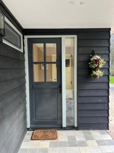 a black door on a house with a wreath on it at In de Hemmele bij Maria in Lievelde
