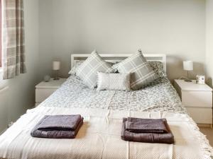 a bedroom with a white bed with two towels on it at Stroma in Edderton