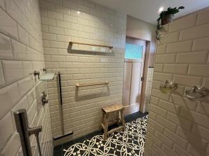 a bathroom with a shower with a bench in it at In de Hemmele bij Maria in Lievelde +30 photos