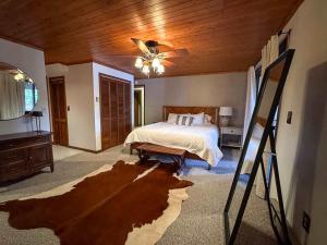a bedroom with a bed and a ceiling fan at Hilltop - Bouchard Shores Resort in Minocqua