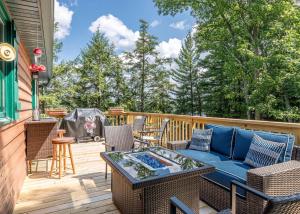 a patio with a blue couch and chairs on a deck at Hilltop - Bouchard Shores Resort in Minocqua
