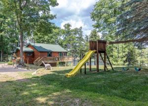 a playground with a slide and a house at Hilltop - Bouchard Shores Resort in Minocqua