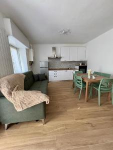 a living room with a green couch and a table at LA CASETTA - Clusone in Clusone