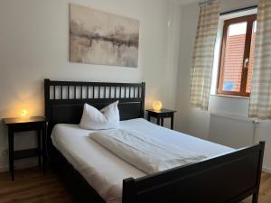 a bedroom with a bed with white sheets and pillows at Weingärtner Appartements in Mannheim