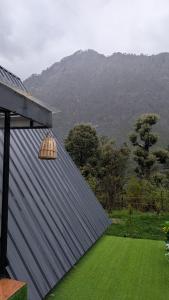 a light on the roof of a house with a mountain at Kasol A-Frame Cottage in Kasol