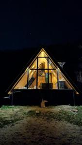 a large house with glass windows on the side of it at Kasol A-Frame Cottage in Kasol