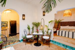a living room with a table and some plants at Riad Taww'Ami in Marrakesh