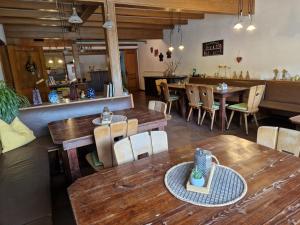a restaurant with wooden tables and chairs and a counter at Ferien- und Reiterhof Ochsenkopf in Missen-Wilhams