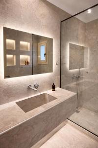 a bathroom with a large sink and a shower at MykoNest in Agios Stefanos +32 photos