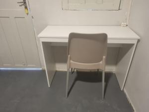 a white desk with a chair next to a door at Hotel Giselle Boutique in Boa Vista +10 photos