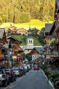 a street with cars parked on the side of a mountain at Ruisseau One Apartment -Snow and Trek Montriond in Montriond