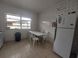 a kitchen with a table and a white refrigerator at Hostel Pantanal Em Florianópolis in Florianópolis +41 photos