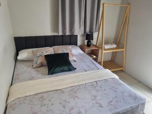 a bed with a green pillow on top of it at Hotel Giselle Boutique in Boa Vista