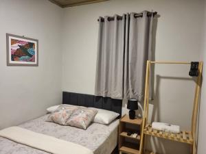 a small bedroom with a bed with a curtain at Hotel Giselle Boutique in Boa Vista