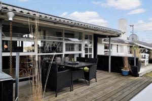 a patio with a table and chairs on a deck at HA344-Saeby-Annesvej-1 in Sæby