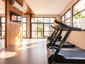 a gym with a treadmill in a room with windows at Xtay Vila Madalena - Stay close to everything with an outdoor pool and access to the best coworking spaces in Vila Madalena in São Paulo
