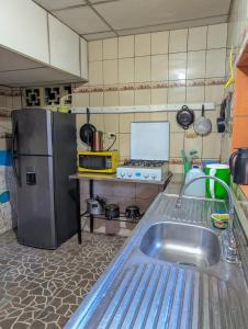 a kitchen with a sink and a refrigerator at Casa Liz in Managua