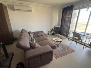 a living room with a brown couch and a table at Ta' Cenc Residence Block C, Apt 4 in Sannat