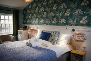 a bedroom with a bed with a blue and white comforter at Redmire Village Pub in Redmire