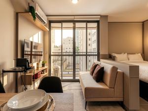 a hotel room with a bed and a couch at Xtay Vila Madalena - Stay close to everything with an outdoor pool and access to the best coworking spaces in Vila Madalena in São Paulo