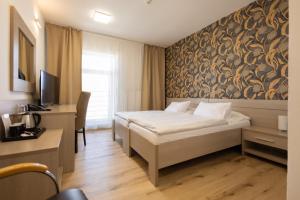 ein Hotelzimmer mit Bett und Schreibtisch in der Unterkunft Hotel Dastan in Levice