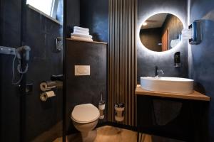 ein Badezimmer mit Waschbecken, Toilette und Spiegel in der Unterkunft Hotel Dastan in Levice