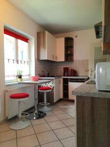 a kitchen with two red bar stools in it at Ferienwohnung Berthold WG 6 in Blankenburg