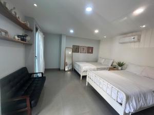a bedroom with two beds and a couch in it at Lemon House in Quy Nhon +5 photos