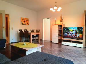 a living room with a television and a dining table at Ferienwohnung Berthold WG 6 in Blankenburg
