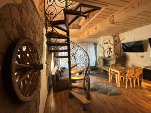 a room with a spiral staircase and a living room at Domki Pod Góralskim Niebem in Zakopane