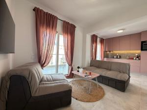 a living room with a couch and a table at Villa Maria Apartments by BookVillaEU in Nea Kallikrateia