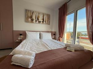 a bedroom with a large bed with a large window at Villa Maria Apartments by BookVillaEU in Nea Kallikrateia +82 photos