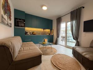 a living room with a couch and a table at Villa Maria Apartments by BookVillaEU in Nea Kallikrateia