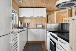 a kitchen with white cabinets and black counter tops at OH156-Hadsund-Halvrebene-26 in Hadsund