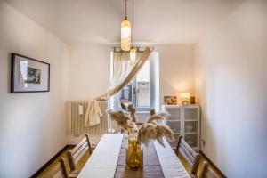 a dining room with a table with a vase of flowers at Casa Caramello in Faggeto Lario 