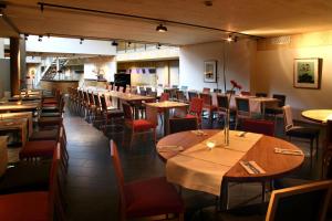 a restaurant with tables and chairs in a room at Scandic Stiklestad in Verdal
