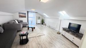 a living room with a couch and a tv at Ferienwohnung Melody in Weisweil