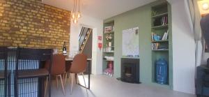 a dining room with a table and chairs and a fireplace at Stylish Cottage with Loft Sleeps 4 in Dublin +14 photos