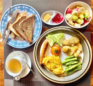 a table with two plates of breakfast food and a cup of tea at The Mountain House in Pokhara