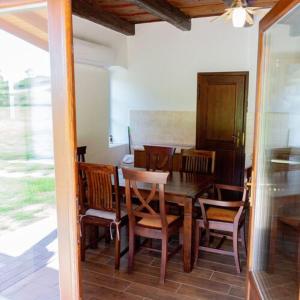 a dining room with a wooden table and chairs at Feketebács Nyaralóház in Káptalantóti