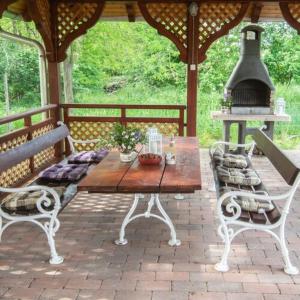 a wooden table and chairs on a patio with a stove at Feketebács Nyaralóház in Káptalantóti +2 photos